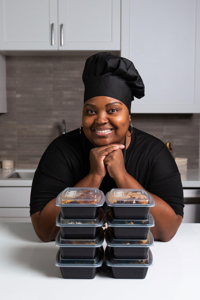 a photo of Chef Tanya posing with some of her prepped meal boxes